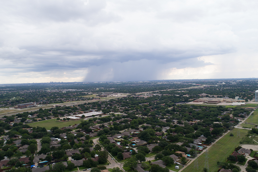 Contact - Aerial View of Suburban Texas Town on a Cloudy Day With a Rain Storm in the Distance